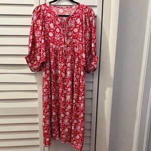 Loose, flowing red dress with white flowers.